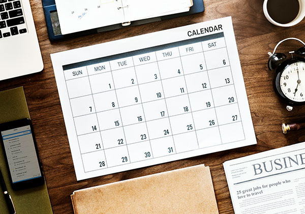 Picture of a large calendar on top of a neat business desk